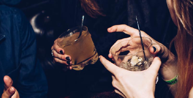 Personas agarrando una copa de bebida